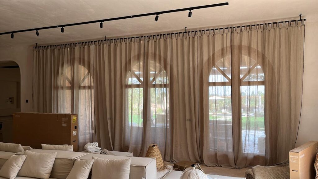 IBI HOUSE és l’empresa especialitzada en tapisseria i cortinatges de luxe que ofereix una àmplia gamma de serveis per a xalets i apartaments exclusius a Andorra i al Pirineu. Els nostres treballs de tapisseria inclouen: tapissar sofàs, butaques, cadires, capçals de llit i bancs, renovació de mobles d’autor, confecció de coixins personalitzats i fundes a mida, així com restauració de peces antigues amb acabats impecables. En el camp del cortinatge, confeccionem cortines i estors amb teixits prèmium, incorporant sistemes tècnics que permeten controlar la llum i la privacitat amb elegància. Treballem amb materials com vellut, seda, lli i altres fibres nobles, tant en dissenys clàssics com en patrons més moderns, adaptant-nos sempre a l’estil i les necessitats del client. Altres serveis que oferim inclouen la instal·lació de cortines amb sistemes domòtics, entapissats per a parets i panells decoratius, així com assessorament personalitzat en la selecció de teixits, combinacions cromàtiques i acabats per garantir una coherència total en el disseny interior. Cada projecte és únic, i en IBI HOUSE combinem artesania, tecnologia i disseny innovador per aconseguir espais exclusius, sofisticats i totalment personalitzats, garantint la màxima qualitat i un servei complet des de la concepció fins a la instal·lació final. La nostra empresa IBI HOUSE de tapisseria de luxe a Andorra fa treballs especialitzats en la confecció, restauració i instal·lació de peces tèxtils per a la decoració interior d’habitatges exclusius, xalets i apartaments prèmium. Els serveis habituals inclouen tapissar sofàs, butaques, cadires, capçals de llit i bancs amb teixits d’alta gamma, així com renovar i personalitzar mobles d’autor. També confeccionen cortines i cortinatges a mida per a grans finestrals i sistemes de control solar, utilitzant materials nobles com el vellut, la seda, el lli i altres teixits selectes. (De les millors fàbriques de teixits per a decoració d’Itàlia) Entre els treballs més sol·licitats s’inclouen: Tapisseria de sofàs, butaques, cadires i mobles d’autor. Elaboració de cortines, estors i cortinatges a mida amb disseny exclusiu. Confecció de coixins decoratius, fundes i accessoris tèxtils personalitzats. Renovació de capçals de llit, banquetes i mobles auxiliars. Instal·lació de cortines tècniques i sistemes domòtics per control solar. Utilització de teixits prèmium amb varietat de textures, colors i estampats. Serveis de restauració per peces antigues o de gran valor artístic. Projectes integrals per xalets, apartaments, hotels i boutiques i cases de luxe. Disseny i confecció d’entapissats per parets i panells decoratius. Assessorament personalitzat per seleccionar materials, acabats i combinacions òptimes. A més, la nostra empresa especialitzada en cortinatges de luxe i ens encarreguem de crear solucions a mesura que aporten elegància, funcionalitat i exclusivitat a qualsevol espai, dissenyant cortines i entapissats que s’adapten a les tendències actuals, les demandes del client i l’estil arquitectònic de cada projecte.